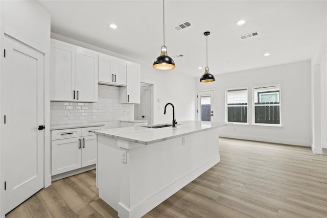 7819 Brownsville Ave, Dallas, TX 75216 - kitchen with backsplash, white cabinetry, visible vents, and a sink