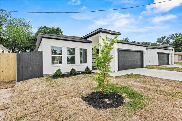 7819 Brownsville Ave, Dallas, TX 75216 - contemporary house featuring driveway, a garage, fence, and a front yard