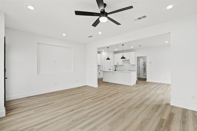 7819 Brownsville Ave, Dallas, TX 75216 - unfurnished living room featuring a sink, visible vents, recessed lighting, ceiling fan, and light wood-style floors