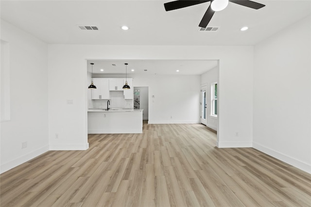 7819 Brownsville Ave, Dallas, TX 75216 - unfurnished living room featuring recessed lighting, light wood finished floors, visible vents, and a sink