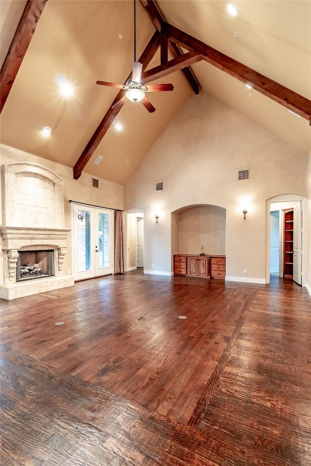 unfurnished living room with ceiling fan, visible vents, high vaulted ceiling, wood finished floors, and beam ceiling