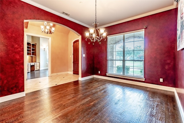 unfurnished dining area featuring a chandelier, crown molding, arched walkways, and visible vents