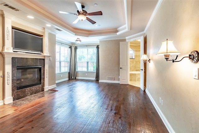 unfurnished living room featuring visible vents, wood finished floors, a raised ceiling, and ornamental molding