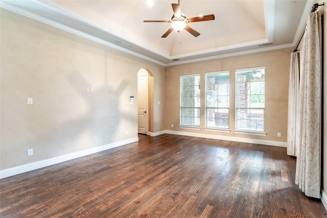 unfurnished room with arched walkways, a raised ceiling, ornamental molding, and ceiling fan