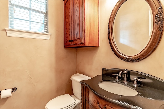 half bathroom featuring vanity and toilet
