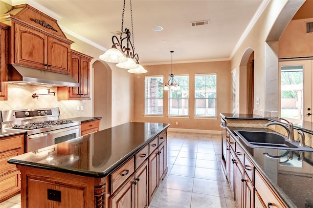 kitchen with a sink, range with two ovens, extractor fan, visible vents, and arched walkways