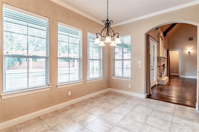 unfurnished dining area with a notable chandelier, baseboards, visible vents, crown molding, and arched walkways