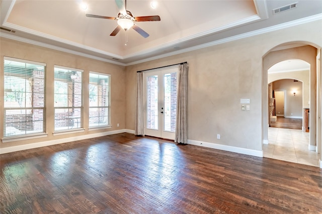 unfurnished room featuring ceiling fan, a raised ceiling, visible vents, and wood finished floors