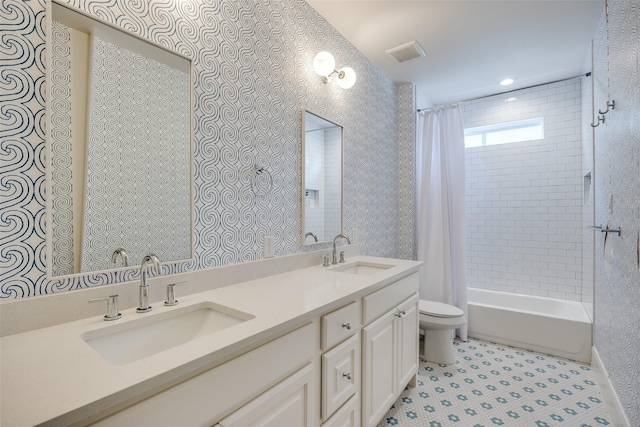 full bathroom with double vanity, toilet, visible vents, and a sink
