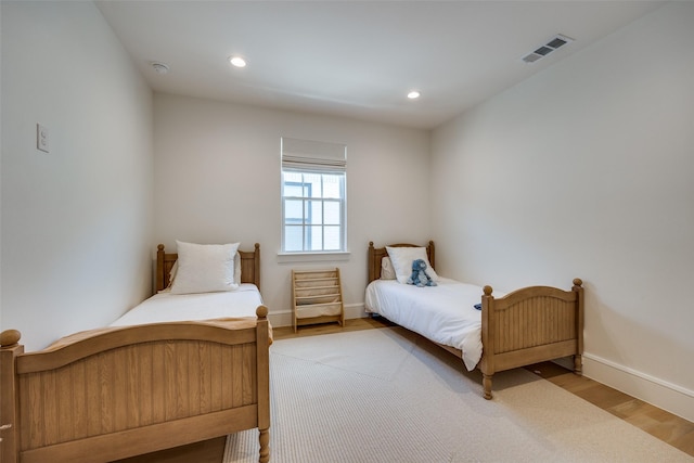 bedroom with baseboards, recessed lighting, visible vents, and wood finished floors