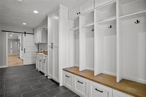 mudroom featuring a barn door and recessed lighting