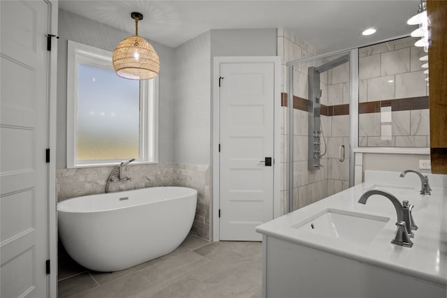 full bathroom with double vanity, a sink, a freestanding bath, tile walls, and a shower stall