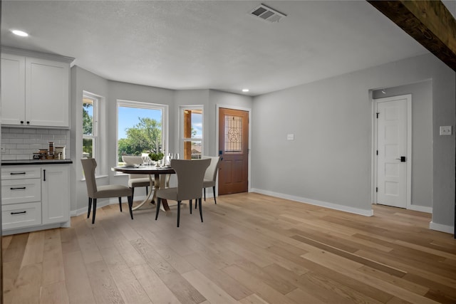 dining space featuring light wood-type flooring, visible vents, baseboards, and recessed lighting