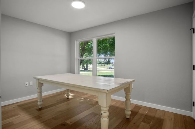 dining space featuring baseboards and wood finished floors