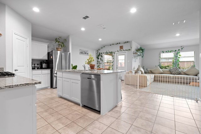 716 Emmons Creek St, Justin, TX 76247 - kitchen featuring white cabinets, appliances with stainless steel finishes, light tile patterned floors, and open floor plan