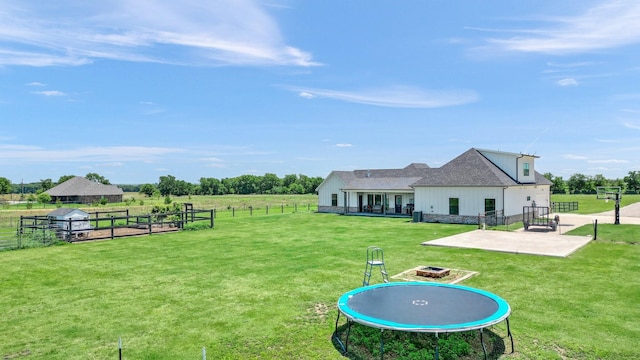 view of yard with a rural view, a patio, and fence