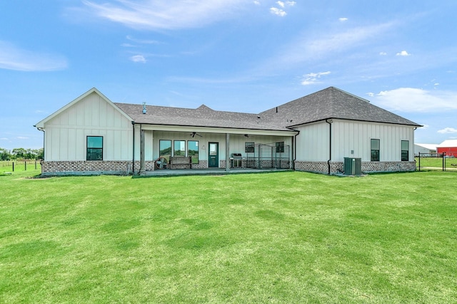 back of house with a yard, board and batten siding, central AC unit, and a ceiling fan