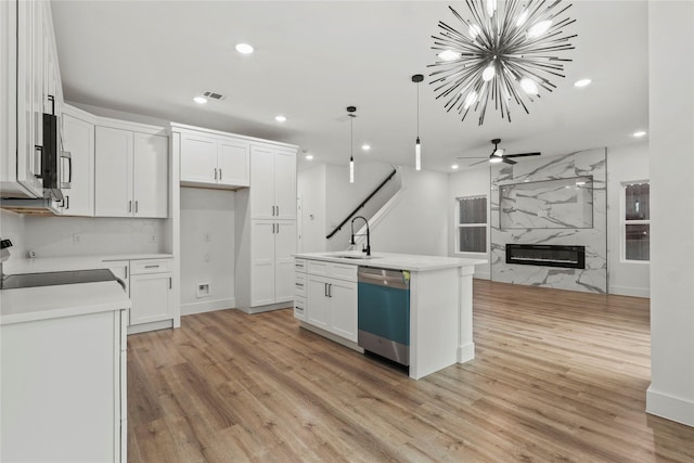 kitchen featuring light wood-type flooring, a sink, range, and stainless steel dishwasher