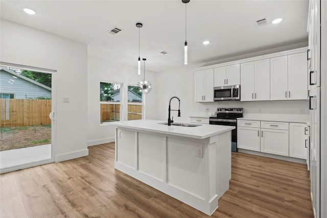 kitchen with stainless steel appliances, light wood-style flooring, visible vents, and a sink