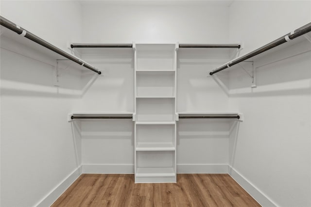 walk in closet with wood finished floors