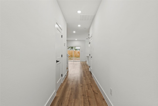 corridor featuring visible vents, wood finished floors, baseboards, and recessed lighting