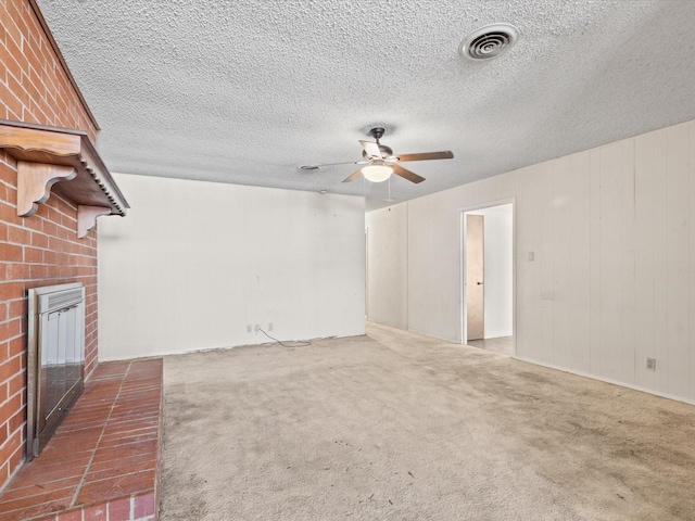 113 Delmore Dr, Hillsboro, TX 76645 - unfurnished living room featuring visible vents, a fireplace, a ceiling fan, and carpet floors