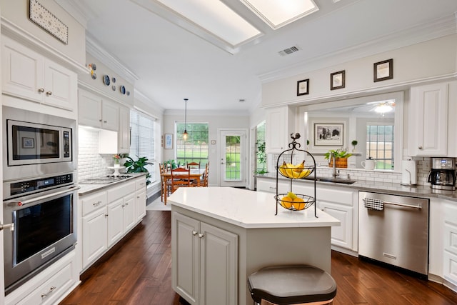 5125 Golden Ln, Fort Worth, TX 76123 - kitchen featuring a sink, visible vents, appliances with stainless steel finishes, decorative backsplash, and ornamental molding