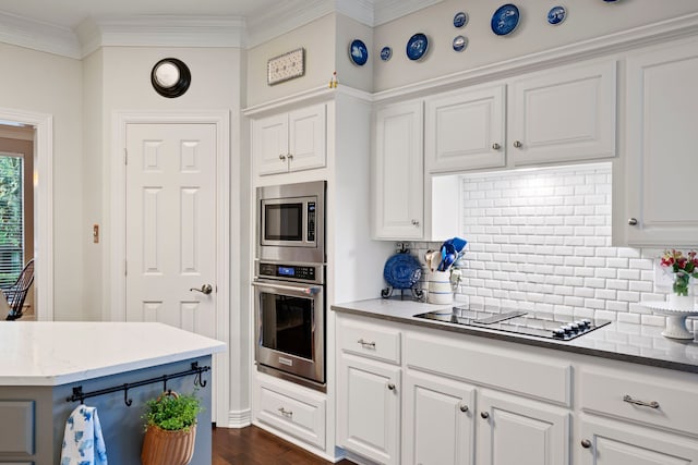 5125 Golden Ln, Fort Worth, TX 76123 - kitchen with crown molding, dark wood finished floors, white cabinetry, backsplash, and appliances with stainless steel finishes