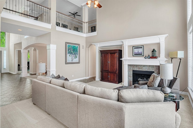 4600 Winter Park Dr, Richardson, TX 75082 - living area featuring arched walkways, baseboards, a high ceiling, ceiling fan, and a premium fireplace