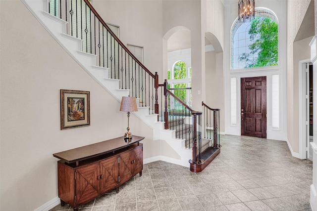 4600 Winter Park Dr, Richardson, TX 75082 - foyer featuring a towering ceiling, arched walkways, stairs, baseboards, and a chandelier