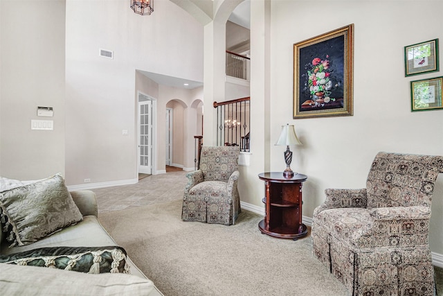 4600 Winter Park Dr, Richardson, TX 75082 - carpeted living area with arched walkways, baseboards, and a high ceiling