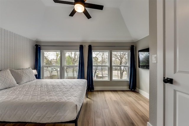 807 Florence St, Mckinney, TX 75069 - bedroom featuring wood finished floors, vaulted ceiling, an accent wall, baseboards, and wallpapered walls
