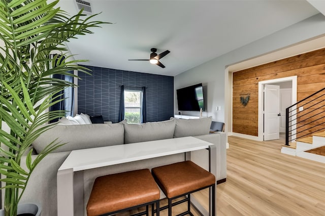 807 Florence St, Mckinney, TX 75069 - living room featuring baseboards, ceiling fan, an accent wall, light wood-style floors, and stairs