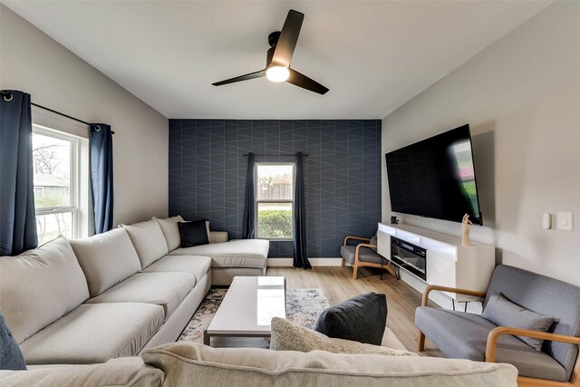 807 Florence St, Mckinney, TX 75069 - living area featuring an accent wall, ceiling fan, plenty of natural light, and wood finished floors