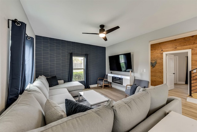 807 Florence St, Mckinney, TX 75069 - living area with an accent wall, light wood-style flooring, a ceiling fan, and wood walls