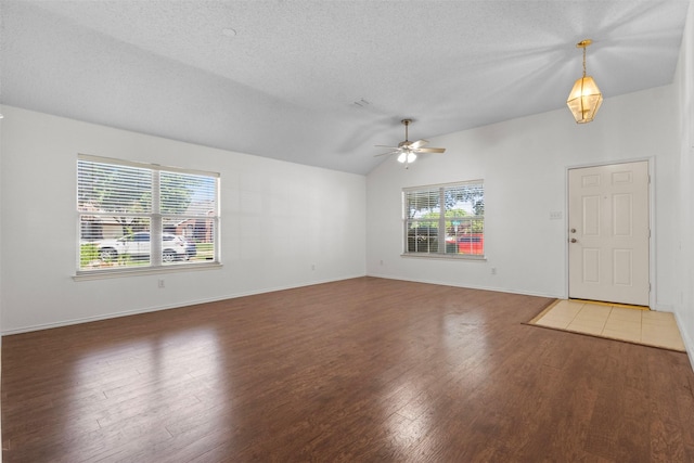 304 E Clover Park Dr, Fort Worth, TX 76140 - unfurnished living room featuring wood finished floors, a textured ceiling, baseboards, ceiling fan, and lofted ceiling