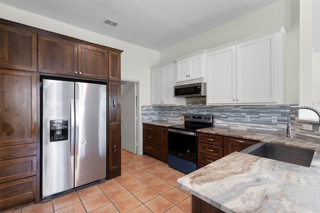 304 E Clover Park Dr, Fort Worth, TX 76140 - kitchen featuring a sink, stainless steel appliances, white cabinets, decorative backsplash, and light tile patterned flooring