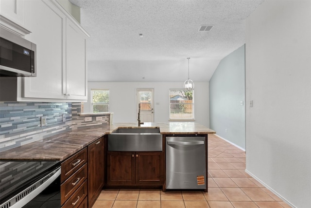 304 E Clover Park Dr, Fort Worth, TX 76140 - kitchen with a textured ceiling, a sink, a peninsula, backsplash, and appliances with stainless steel finishes
