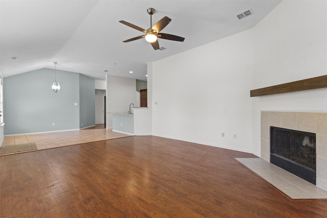 304 E Clover Park Dr, Fort Worth, TX 76140 - unfurnished living room with wood finished floors, a fireplace, visible vents, ceiling fan, and lofted ceiling