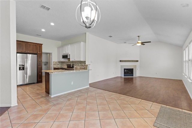 304 E Clover Park Dr, Fort Worth, TX 76140 - kitchen with a peninsula, ceiling fan with notable chandelier, stainless steel appliances, tasteful backsplash, and light tile patterned flooring