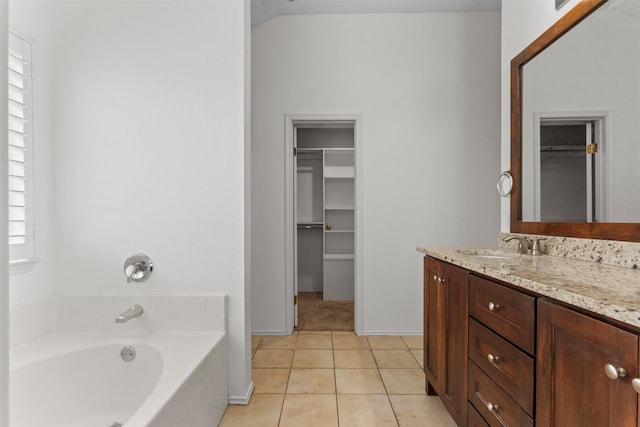 304 E Clover Park Dr, Fort Worth, TX 76140 - bathroom featuring vanity, a walk in closet, a garden tub, and tile patterned floors