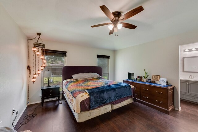 bedroom featuring dark wood-style flooring, a sink, connected bathroom, a ceiling fan, and baseboards