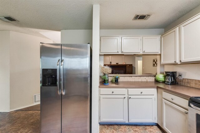 kitchen with stainless steel appliances, white cabinetry, and a textured ceiling