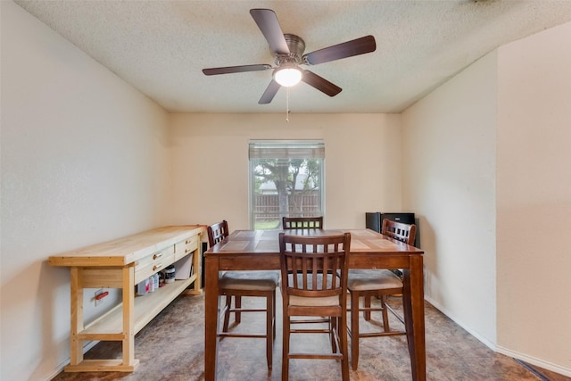 dining room featuring a textured ceiling, a ceiling fan, and baseboards