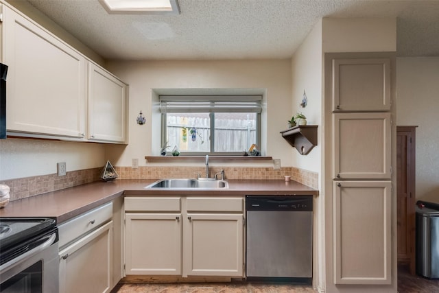 kitchen featuring stainless steel appliances, a sink, tasteful backsplash, and a textured ceiling