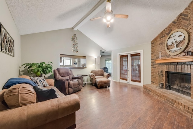 living room featuring ceiling fan, a textured ceiling, wood finished floors, beamed ceiling, and healthy amount of natural light