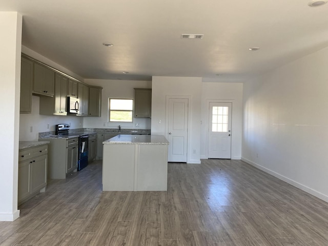106 Sugar Ter, Runaway Bay, TX 76426 - kitchen featuring a kitchen island, visible vents, wood finished floors, and electric range