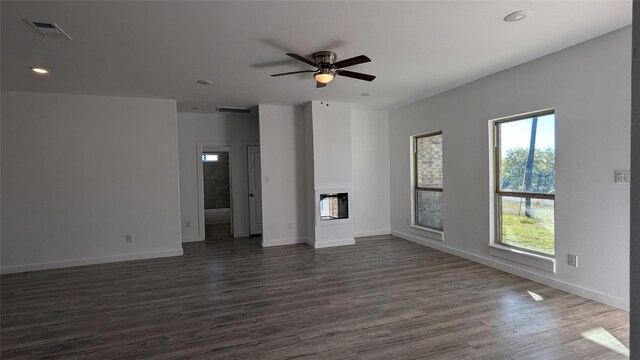 106 Sugar Ter, Runaway Bay, TX 76426 - unfurnished living room with dark wood-style flooring, baseboards, a ceiling fan, and visible vents