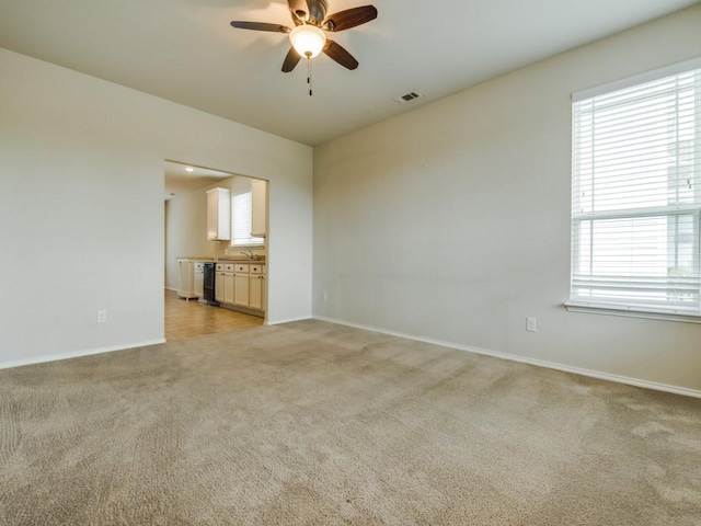 1909 Myers Ct, Providence Village, TX 76227 - unfurnished room with a sink, visible vents, baseboards, ceiling fan, and light colored carpet