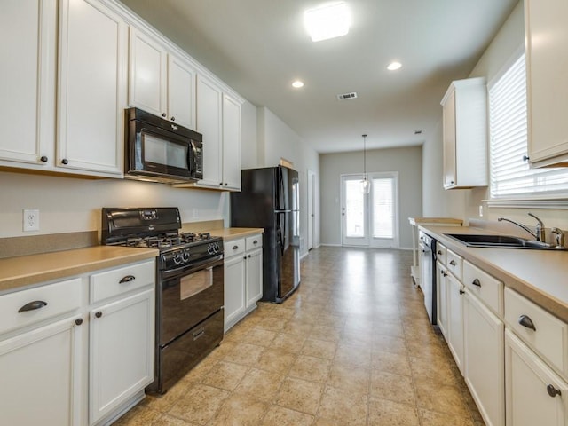 1909 Myers Ct, Providence Village, TX 76227 - kitchen with a sink, black appliances, visible vents, white cabinetry, and light countertops